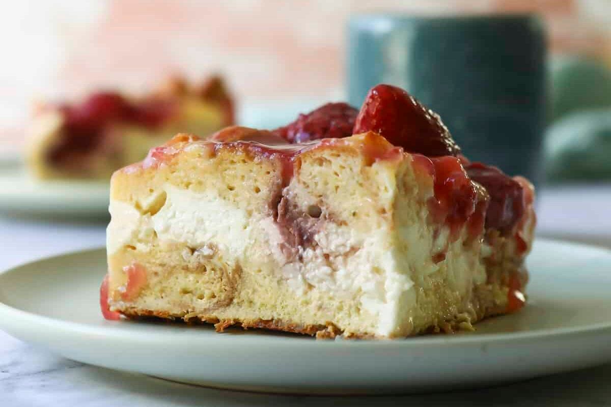 A slice of strawberry French toast casserole with strawberry topping.