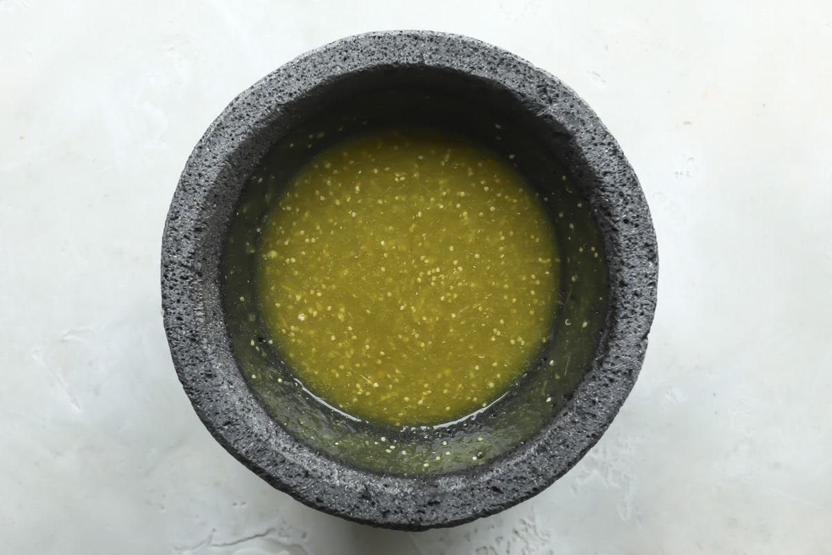 A molcajete with salsa verde (green salsa) inside.